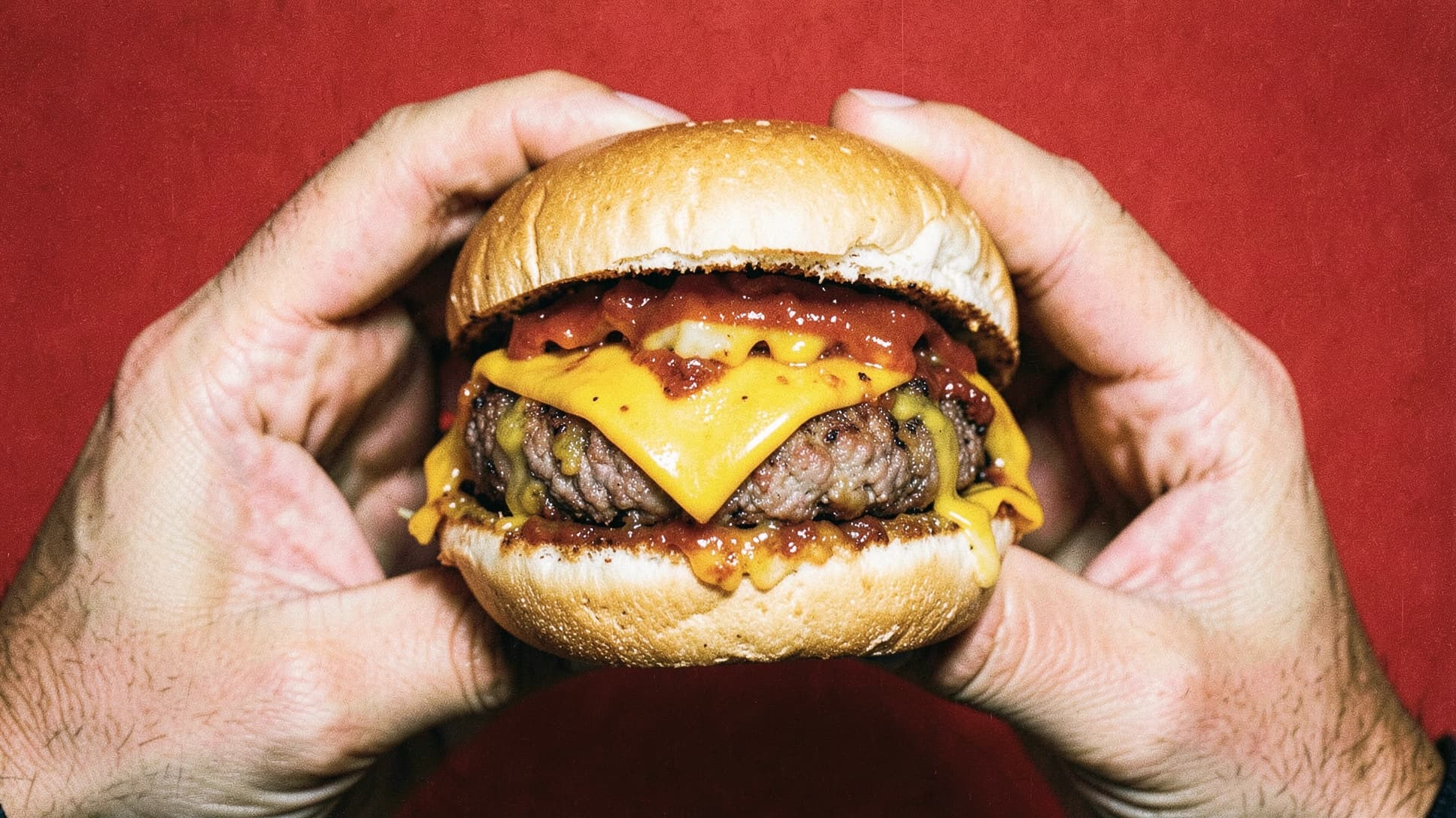 A freshly made burger held in two hands